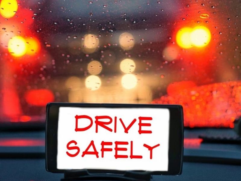 GPS device, on the dashboard of a car with the words "Drive Safely" light blurred background